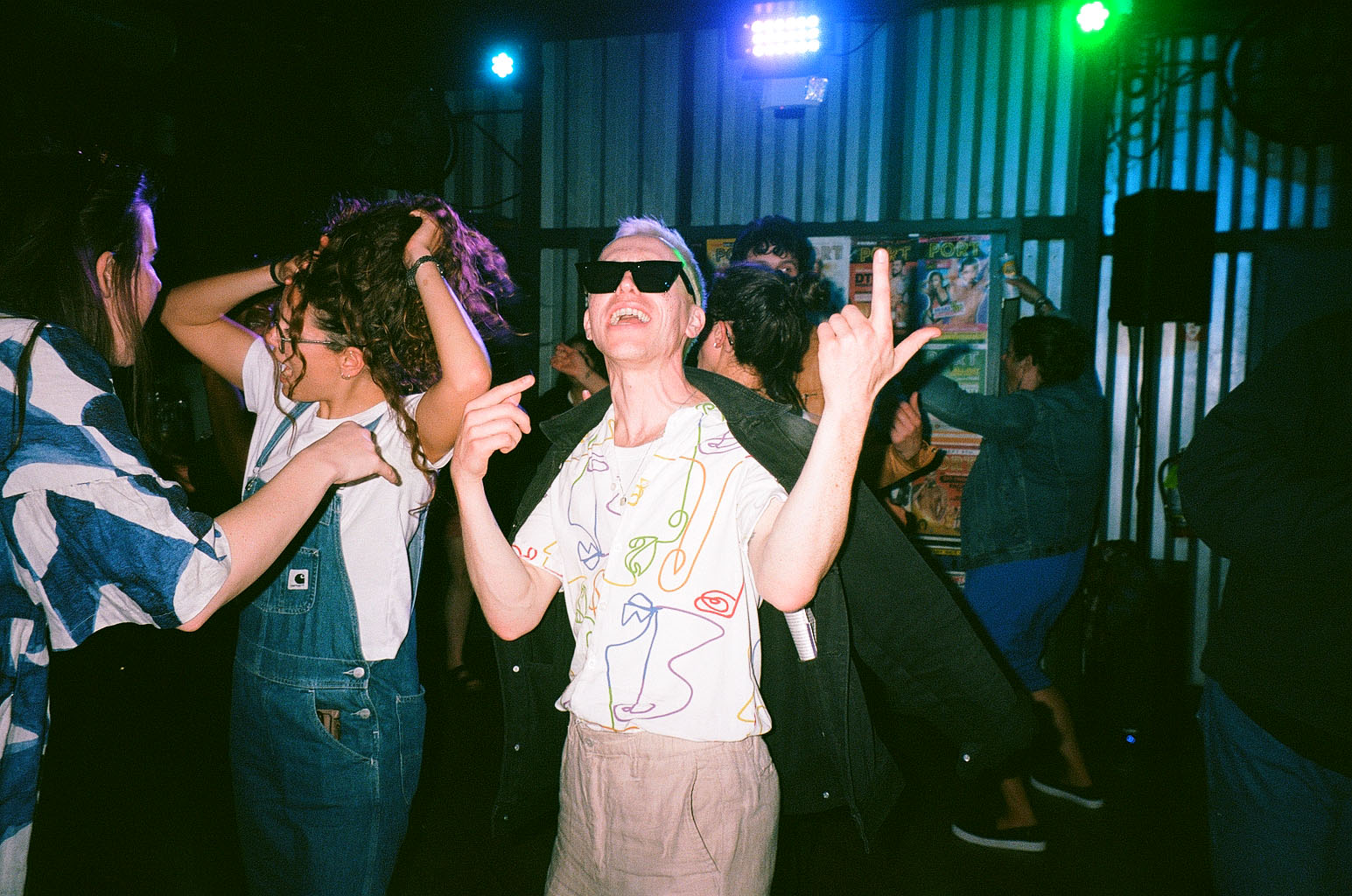 Group dancing under colorful nightlife lighting