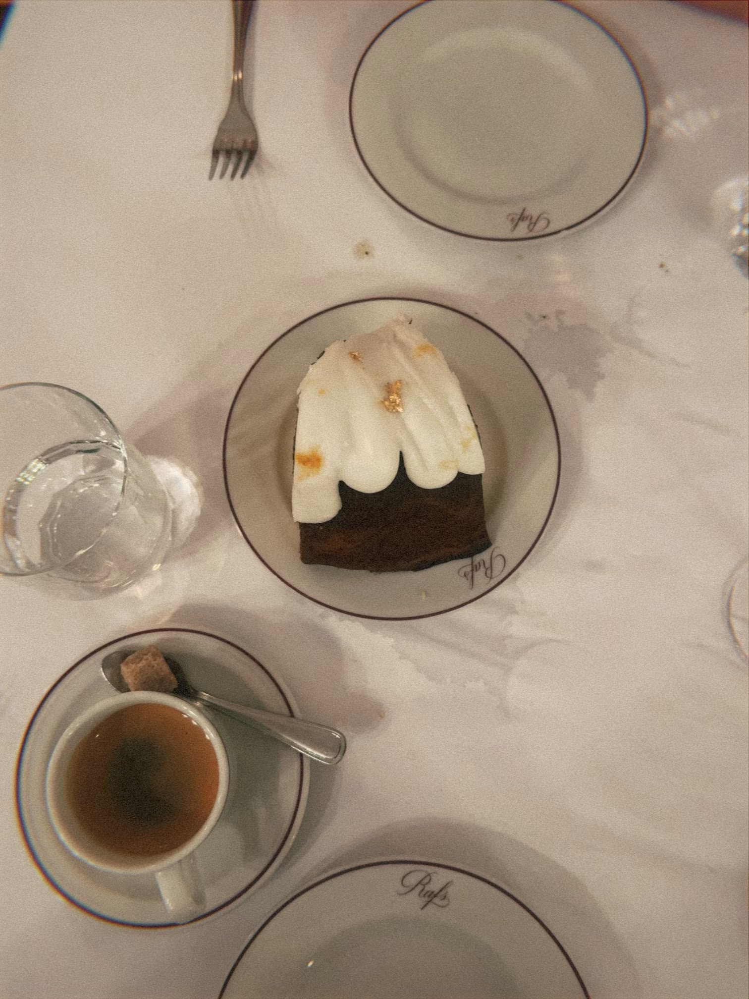 Dessert, espresso, and place settings on a white tablecloth