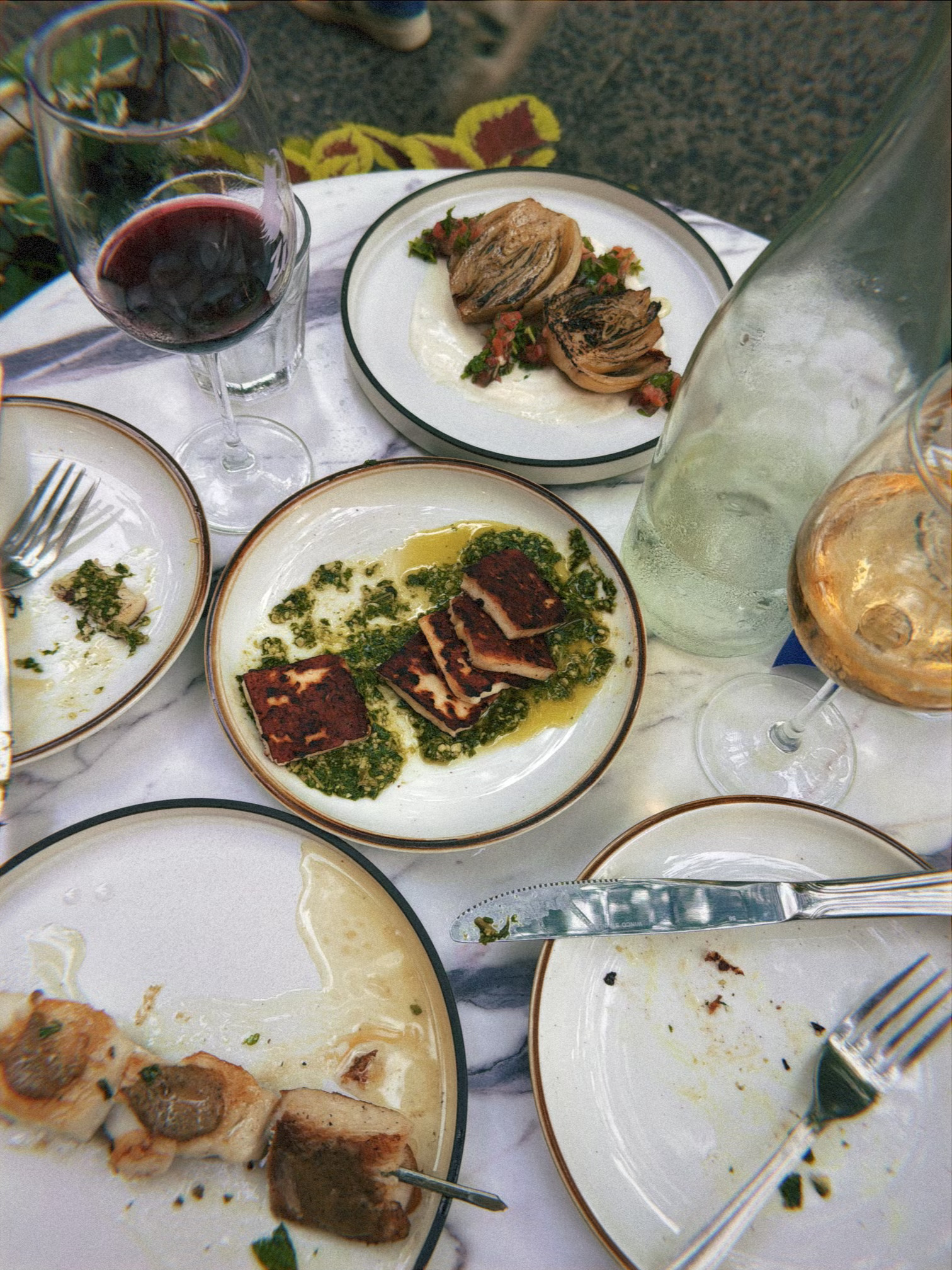Shared meal with plates and wine glasses on a restaurant table