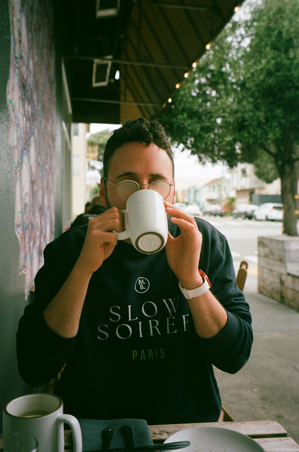 Person looking over a coffee mug at an outdoor café