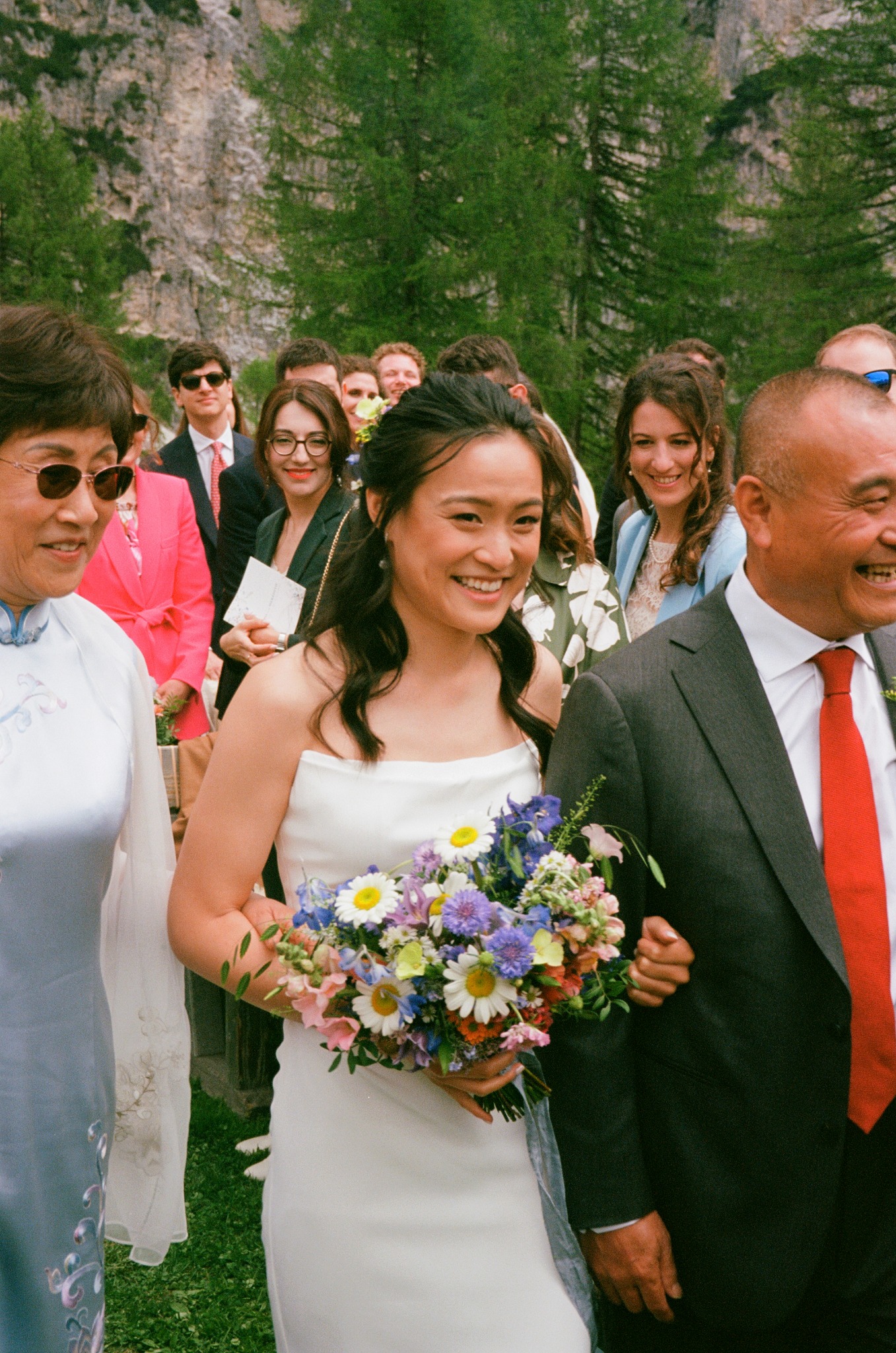 Bride carrying a bouquet while walking with her father